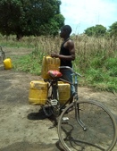 Ein Mann in der Region Mtwara, der Wasser auf dem Fahrrad sammelt
