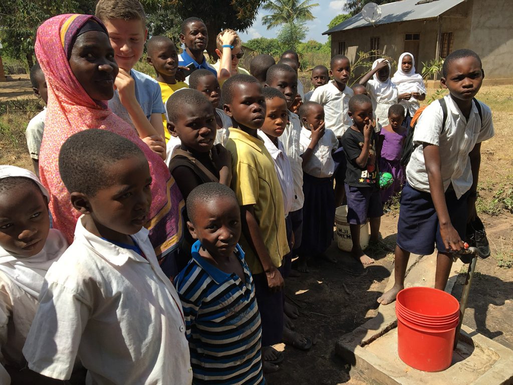 Einheimische Kinder an der Wasserstellen-Pipeline im Chipinpinbi-Projekt, finanziert von African Palms, das Palmkreuze verkauft