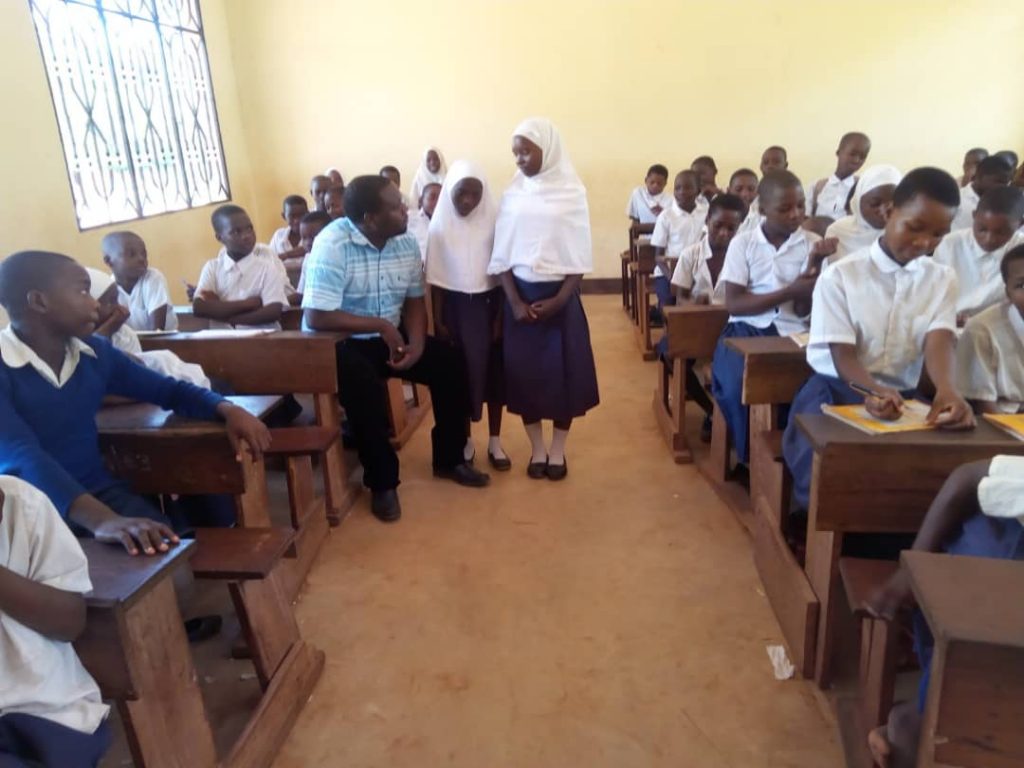 Kinder der Namikunda-Grundschule, einem Dorf, in dem Palmenkreuze hergestellt werden, ein Projekt, das von African Palms finanziert wird, helfen beim Bau weiterer Klassenzimmer